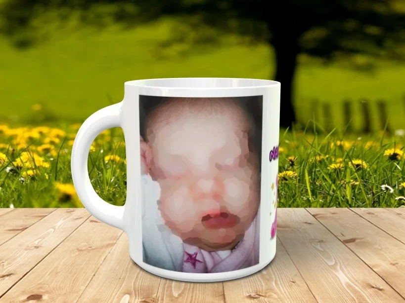 Taza blanca personalizable con una fotografía frontal de un bebé y diseño infantil, apoyada sobre una superficie de madera con fondo natural.