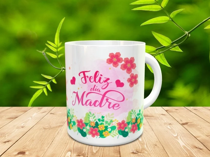 Taza blanca de cerámica personalizada con el texto Feliz día Madre, motivos florales y corazones sobre fondo de madera.