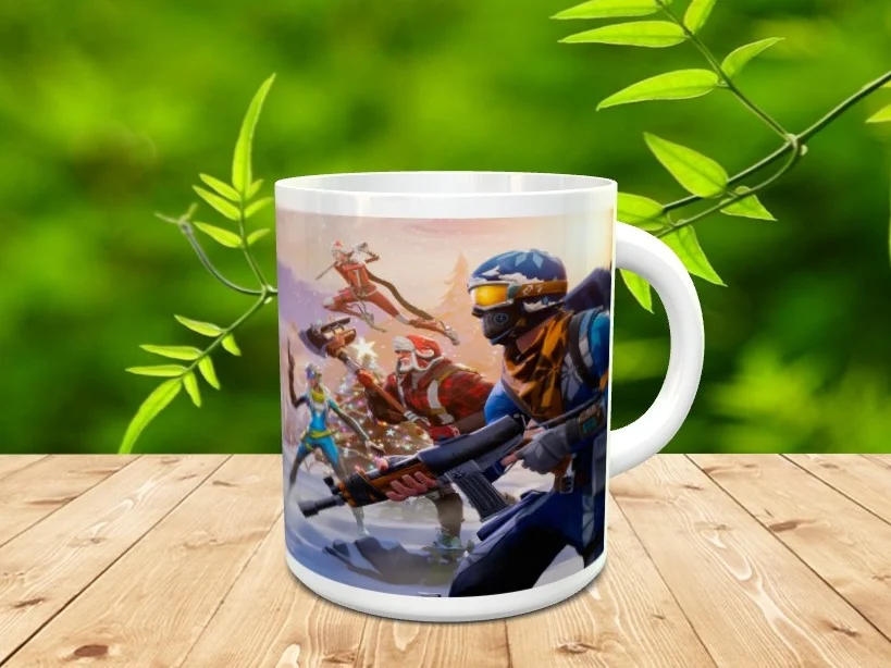 Taza de cerámica blanca decorada con una ilustración de personajes de Fortnite en un entorno nevado, apoyada sobre una superficie de madera con vegetación difuminada al fondo.