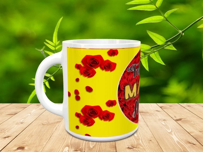 Taza blanca de cerámica personalizada con diseño de fondo amarillo, rosas rojas y mensaje legible sobre superficie de madera.
