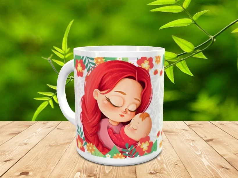 Taza de cerámica blanca con ilustración de una madre pelirroja abrazando a su bebé rodeada de flores, apoyada sobre madera.