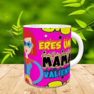 Taza de cerámica blanca con diseño de superheroína y el texto Eres una mamá valiente, apoyada sobre una superficie de madera.