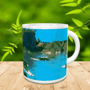 Taza de cerámica blanca con un diseño pixelado de paisaje fluvial y rocoso sobre superficie de madera.