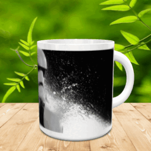 Taza de cerámica blanca con una ilustración monocromática de un personaje sobre superficie de madera.