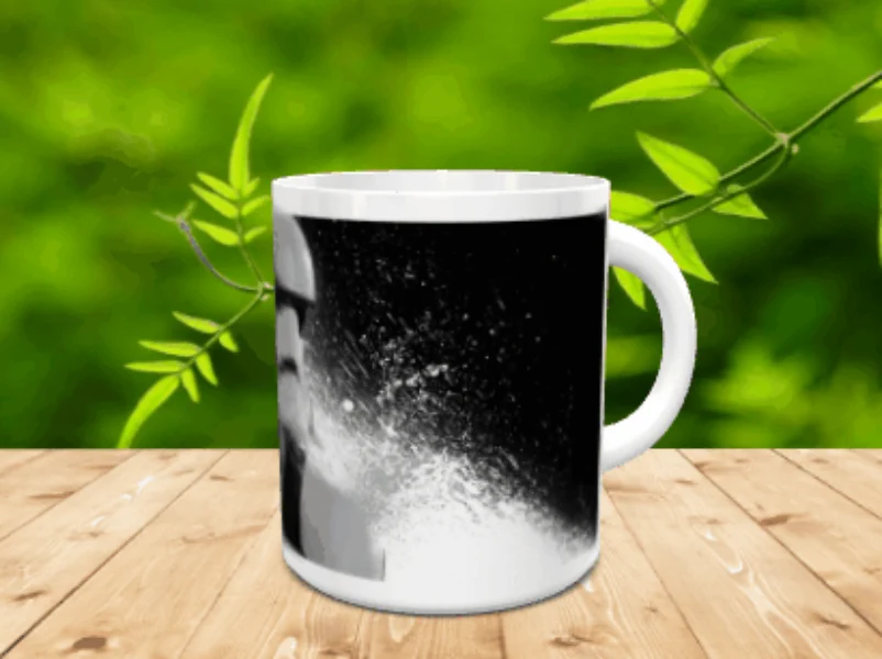 Taza de cerámica blanca con una ilustración monocromática de un personaje sobre superficie de madera.