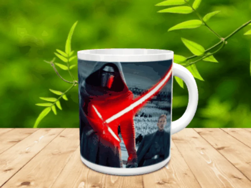 Taza de cerámica blanca decorada con la imagen de un personaje con capa y sable láser rojo sobre fondo oscuro, apoyada en una superficie de madera.
