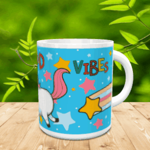 Taza de cerámica blanca decorada con un diseño de unicornio y estrellas sobre fondo azul, apoyada sobre una superficie de madera.
