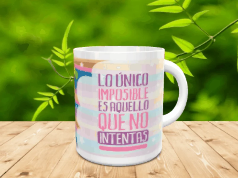 Taza de cerámica blanca con frase motivacional y fondo pastel sobre superficie de madera.