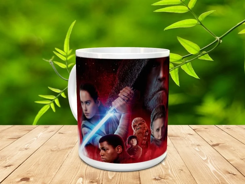 Taza de cerámica blanca decorada con una ilustración de varios personajes de Star Wars en tonos rojizos, sobre una superficie de madera.