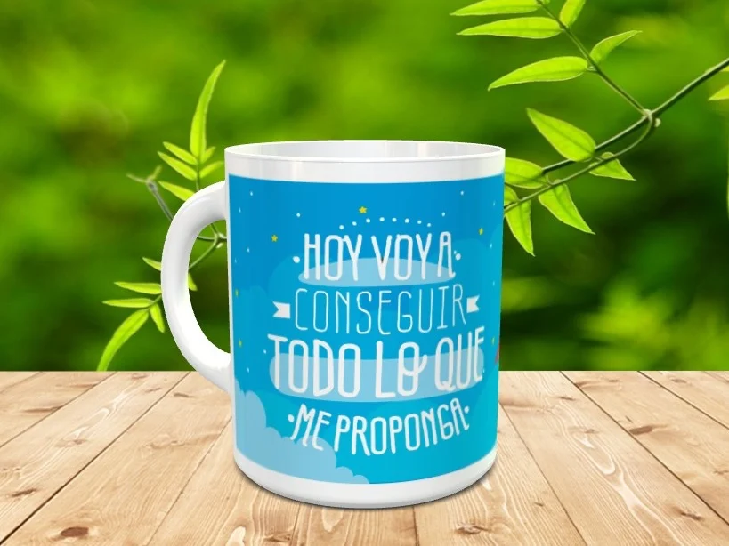 Taza de cerámica blanca con frase motivacional HOY VOY A CONSEGUIR TODO LO QUE ME PROPONGA sobre fondo azul con nubes y estrellas.