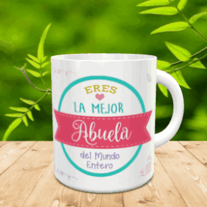 Taza blanca de cerámica personalizada con el mensaje Eres la Mejor Abuela del Mundo Entero, dispuesta sobre una superficie de madera con fondo verde desenfocado.