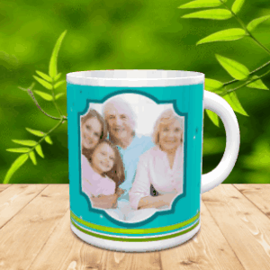 Taza blanca de cerámica personalizada con un diseño en tonos turquesa y verde, mostrando un marco central para fotografía familiar sobre una superficie de madera.