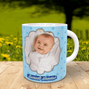 taza blanca de cerámica personalizada con lunares celestes y una fotografía de un bebé en el centro, apoyada sobre una superficie de madera con fondo natural.