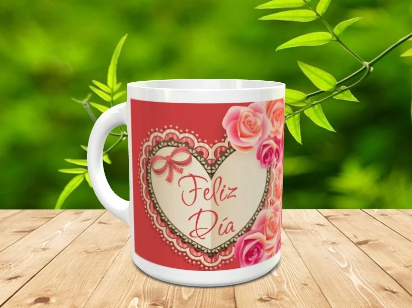 Taza blanca de cerámica decorada con un gran corazón rodeado de encaje, un lazo, rosas y la frase Feliz Día Ref. mama-38x