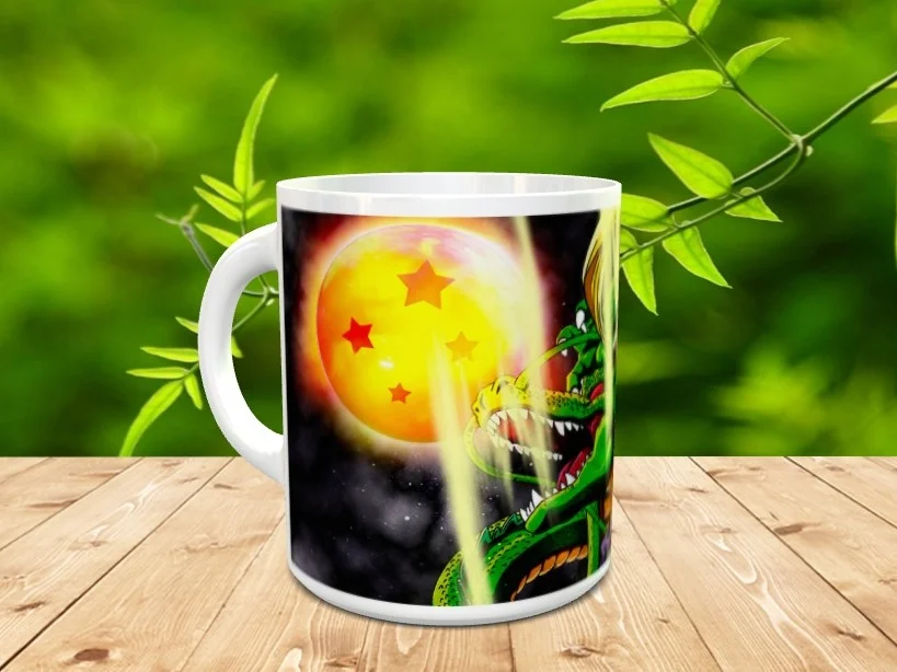 Taza de ceramica blanca con ilustracion del dragon y una esfera brillante sobre mesa de madera con fondo de vegetacion.