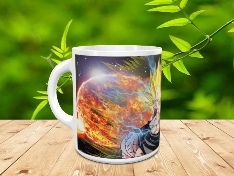 Taza de cerámica blanca con asa, decorada con la ilustración de un personaje de anime de cabello rubio frente a una explosión estelar y rayos azules. La pieza descansa sobre una mesa de madera con vegetación difuminada al fondo. Ref. goku-36x