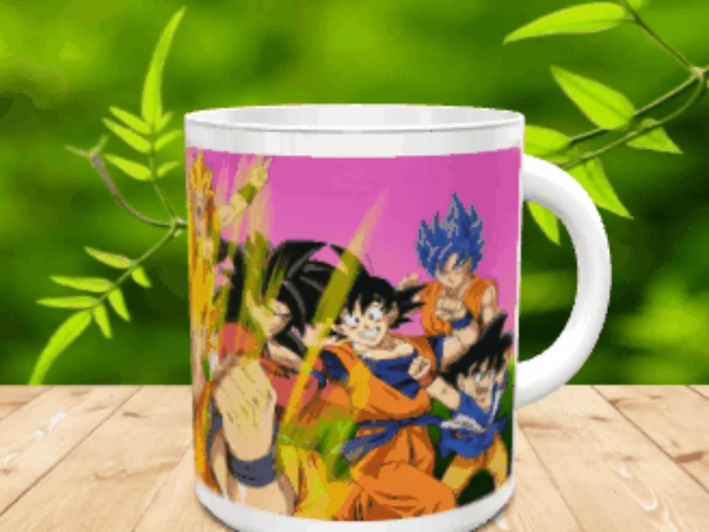 Taza de cerámica blanca con una ilustración colorida de varios personajes de anime sobre fondo rosa, apoyada en una mesa de madera con hojas verdes desenfocadas de fondo. Ref. goku-15x