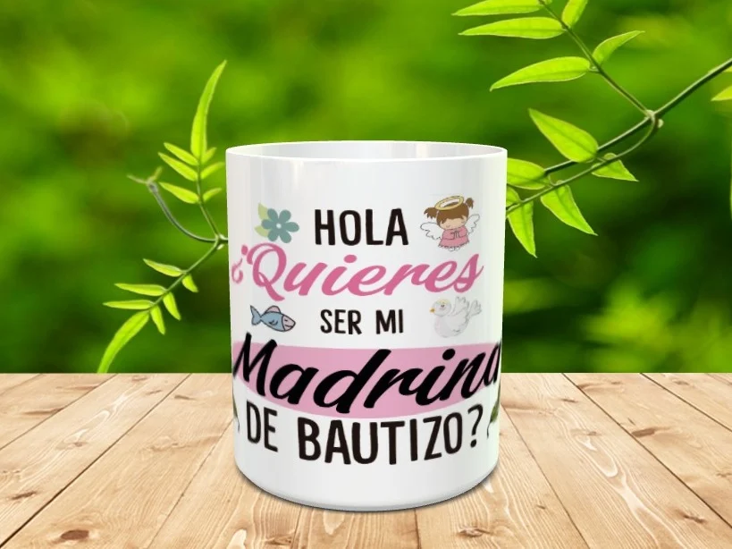 Taza de cerámica blanca para madrina de bautizo con un diseño infantil que incluye texto y dibujos sobre una mesa de madera.