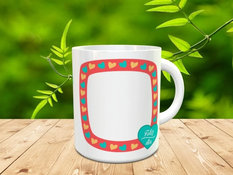 Taza blanca de ceramica personalizada con un marco rojo decorado con corazones de colores y un corazon turquesa con el texto Feliz dia, situada sobre madera.