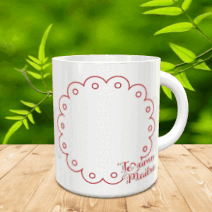 Taza blanca de cerámica con un marco festoneado rojo y la frase Te amo Madre, presentada sobre superficie de madera con fondo vegetal.