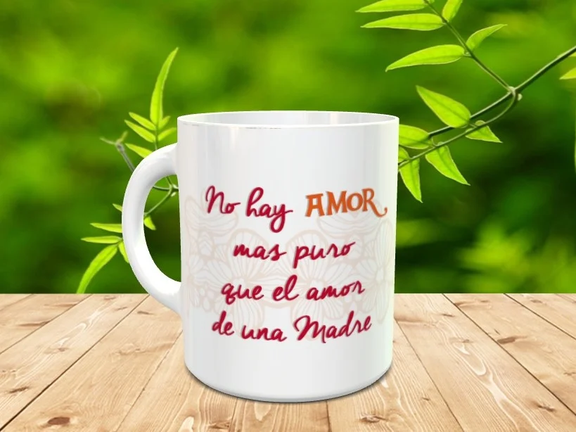 Taza blanca de cerámica para el Día de la Madre con el mensaje No hay amor mas puro que el amor de una Madre sobre fondo floral suave.