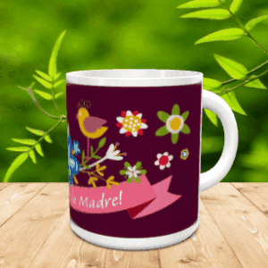 Taza blanca de cerámica en movimiento con fondo morado, un simpático pájaro, motivos florales y una cinta rosa con mensaje, situada sobre superficie de madera y fondo vegetal. Ref. mama-27x