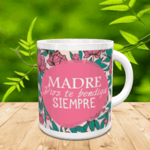 Taza blanca de cerámica con diseño floral y círculo rosa con el mensaje Madre Dios te bendiga siempre sobre una mesa de madera.