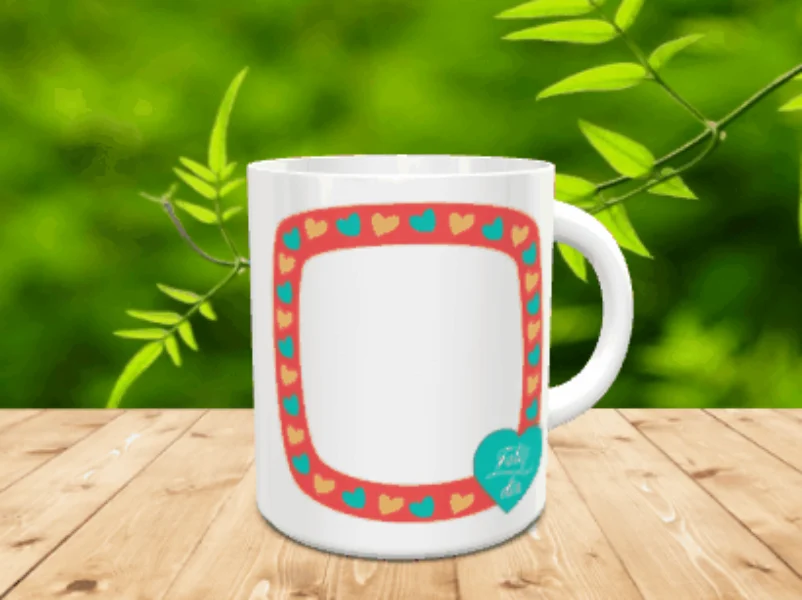 Taza blanca de cerámica con un amplio marco rojo ribeteado de corazones turquesas y amarillos, un corazón inferior con texto y un espacio central apto para fotografía.