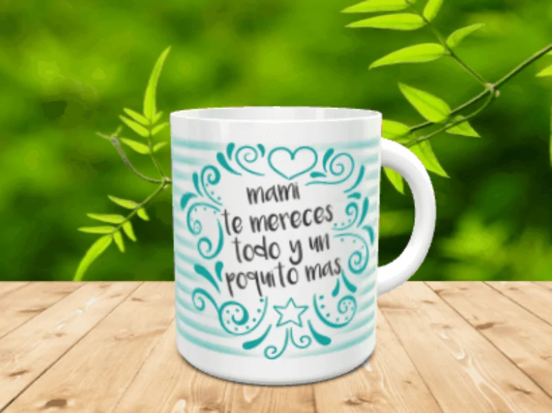Taza blanca de cerámica con rayas turquesas y el mensaje mami te mereces todo y un poquito mas sobre una superficie de madera.