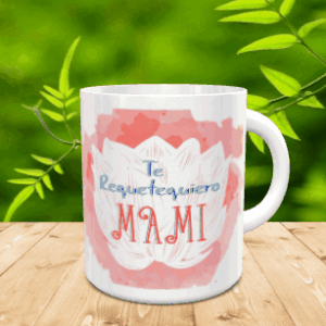 Taza blanca de cerámica con diseño de flor de loto sobre mancha rosa y texto Te Requetequiero Mami, apoyada sobre listones de madera.