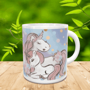 Taza blanca de cerámica decorada con una ilustración de unicornios en tonos pasteles, situada sobre una superficie de madera con fondo vegetal.