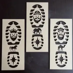 Fotografía de catálogo de tres plantillas de plástico con forma de huella de bota para recrear las pisadas de los Reyes Magos Melchor, Gaspar y Baltasar con dibujos calados de camellos y estrellas.