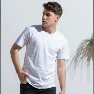 Un modelo masculino joven posa en exteriores vistiendo una camiseta básica de manga corta en color blanco. Fotografía de estilo de vida que muestra el ajuste y la calidad del tejido de algodón de 150 gramos.