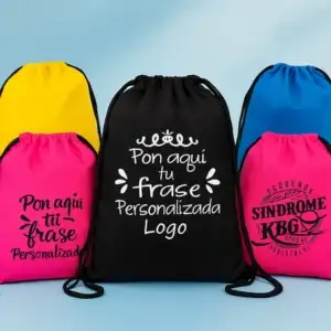 Composición fotográfica con cuatro mochilas de cuerdas en colores amarillo, negro, azul celeste y fucsia. Las mochilas centrales muestran ejemplos de personalización con los textos "Pon aquí tu frase" y "Personalizada Logo".