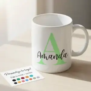 Taza blanca de cerámica personalizada con una gran letra inicial y un nombre superpuesto. Al lado, una carta de colores para elegir la personalización del diseño.